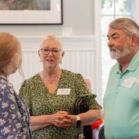 Mick Doxey and Diane Dykstra in conversation with one other event attendee